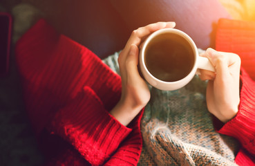 Tea time in the morning. Woman hands holding cup of tea in the morning sunlight.