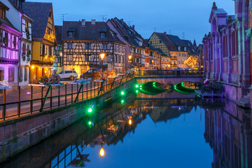 Traditional Alsatian half-timbered houses on the channel in Petite Venise, old town of Colmar, decorated and illuminated at christmas time, Alsace, France