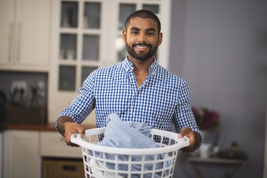 Portrait Of Smiling Man Holding Laundry Basket