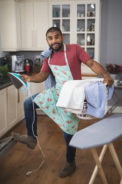 happy man holding laundry basket and iron