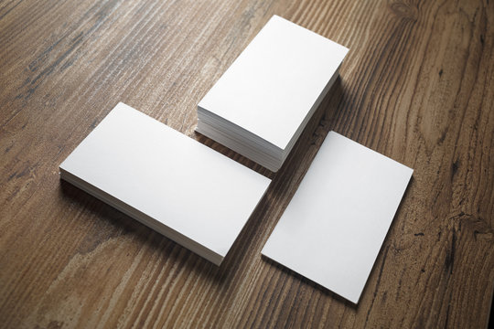 Photo of business cards on wooden office table background. Stacks of business cards. Template for branding identity.