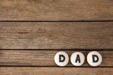 Cupcakes with text dad on wooden plank