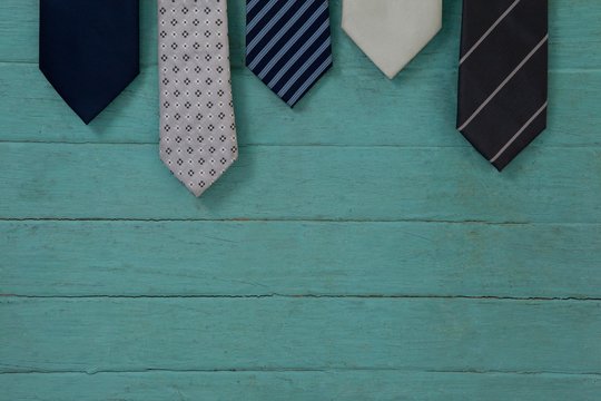 Various ties arranged on wooden plank