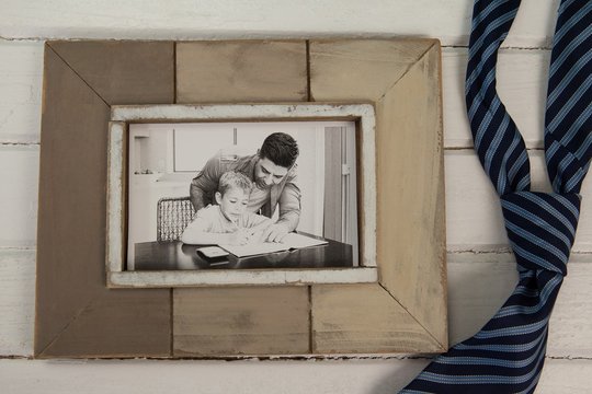 Photo frame and tie on wooden plank