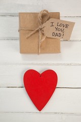 Red heart and gift box on wooden plank