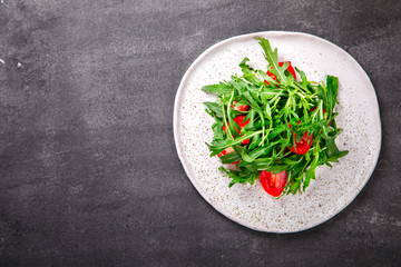  Salad with arugula , Fresh Cherry Tomatoes and Olive oil.Food or Healthy diet concept.Super Food.Vegetarian.Top View.Copy space for Text.