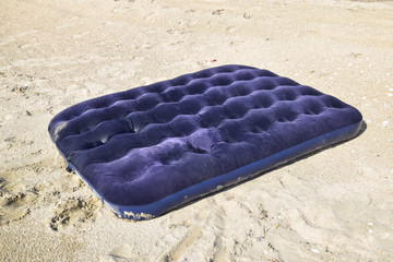 Blue inflatable mattress swimming in the pond