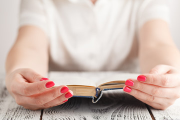 Woman sitting at a table reading a book