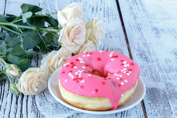 Valentines day breakfast serving with white roses and donut