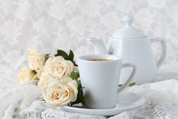 cup with a saucer. Delicate white flowers roses.