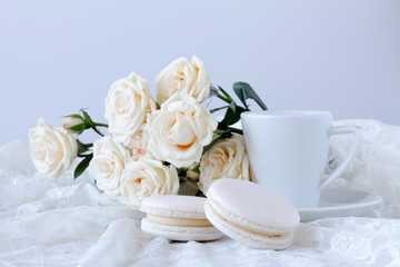 cup of coffee and a bouquet of white roses