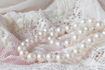 Background of white delicate lace fabric and pearls