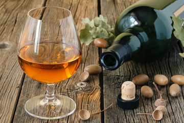 Glass of brandy or cognac on old oak wooden table