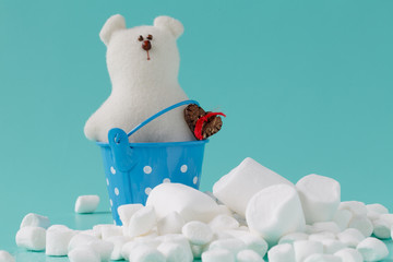 pile of small puffy marshmallows on aquamarine background close up