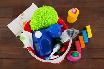 Bucket with cleaning supplies on wooden floor