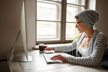 Female working on computer and drinking coffee