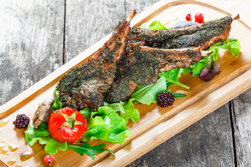Roasted Pork steak on bone stuffed with cheese, grilled vegetables and berries on stone slate background on wooden background close up. Hot Meat Dishes. Top view with copy space
