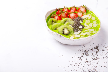 Breakfast Detox Green Smoothie  Bowl with fresh berries,kiwi and chia seeds. Food or Healthy diet concepton a white background.Super Food.selective focus.