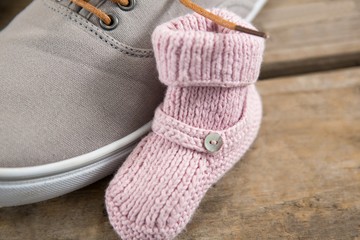 Close up of shoe with baby booties on floor