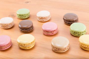 Fresh and tasty and colorful macaroons on a natural oak wood brown table