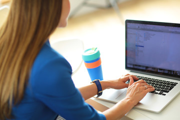 Portrait of beautiful business woman working at her desk with headset and laptop.