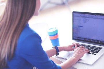 Portrait of beautiful business woman working at her desk with headset and laptop.