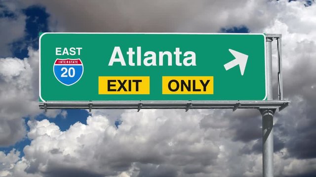 Atlanta Interstate 20 exit sign with time lapse clouds and zoom.