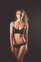 Portrait of young beautiful fitness woman, isolated on black background