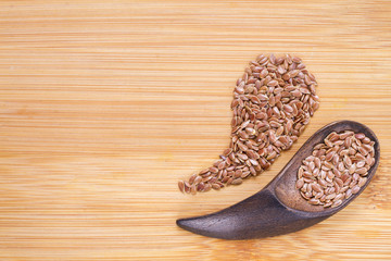 Flax seeds in wooden bowl and spoon