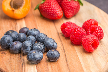 Wooden board with fresh organic fruit and berries