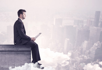 Sales person sitting on building edge in city