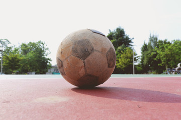 Old futsal ball on red field, old futsal ball is placed on red field 