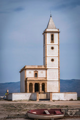 Obraz premium San Miguel Beach and Salinas church with stranded boats, take in Cabo de gata, Almeria, Andalusia, Spain