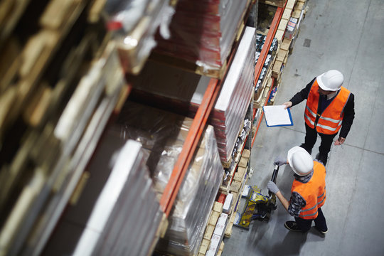 Wholesale workers making revision of goods in warehouse - Powered by Adobe