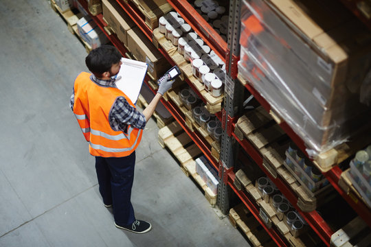 Logistics dispatcher scanning barcodes on packs with goods