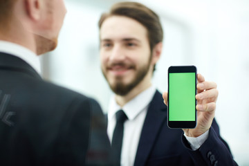 Young employee showing his colleague curious information in smartphone