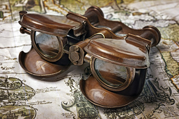 Close-up view of a vintage binoculars on an old retro map