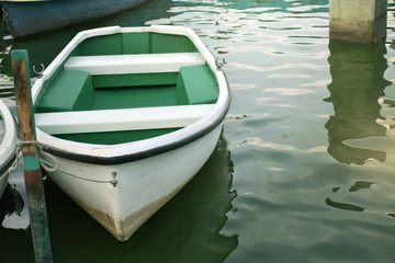 Fototapeta na wymiar White rowboat moored near shore. - Concept boat, quiet, wait, life, hope