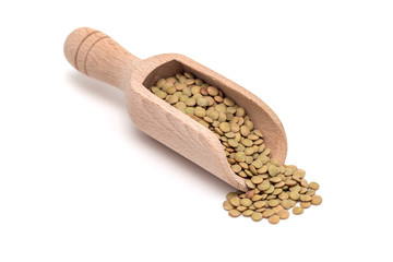 Organic green lentils in wooden scoop, isolated on white background