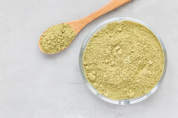 Matcha tea powder on the a plate and in wooden spoon, top view, copy space