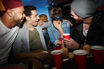 Friendly guys with beer comforting girl at party