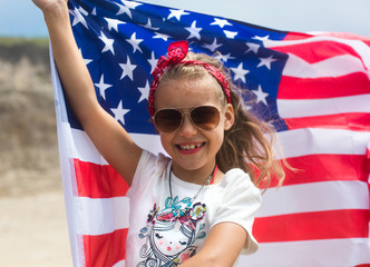 American flag in hands of little girl on US Independence Day July 4th