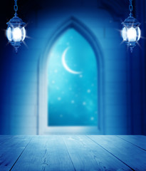 Ramadan Kareem background.Mosque window with lantern lightning and wooden table