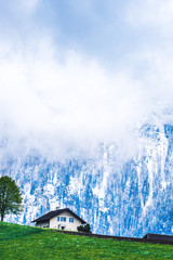 Haus vor Berg mit Tannen und Schnee