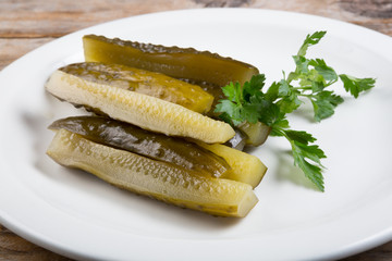 Canned cucumbers on a white plate