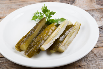 Canned cucumbers on a white plate