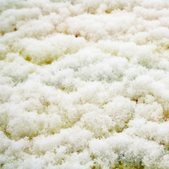 Winter texture. Aged photo. Fluffy snowflakes close up. Snow on the yellow background.