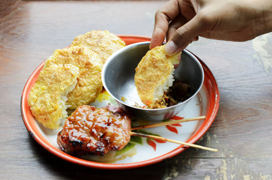 Delicious Khao Jee Sticky rice with egg and grilled pork and spicy suace for Thai e-saan local foods backgrounds