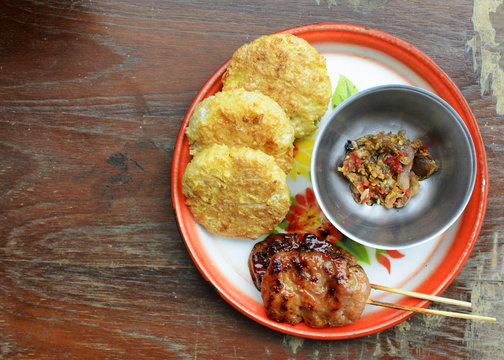 Khao Jee Sticky rice with egg and grilled pork and spicy suace for Thai e-saan local foods backgrounds above