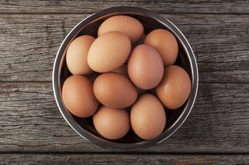 Eggs in bowl on wooden table background